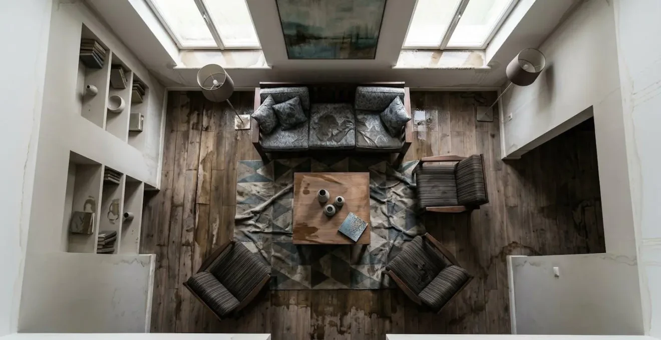 Salon meublé avec canapé et meubles endommagés par l'eau, vue en plongée